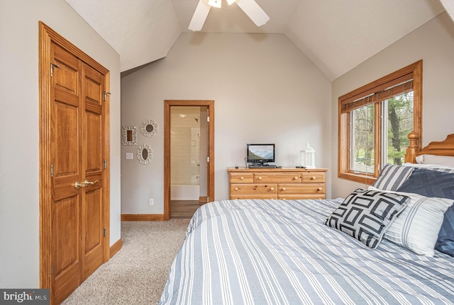 carpeted bedroom with ensuite bath, ceiling fan, and vaulted ceiling