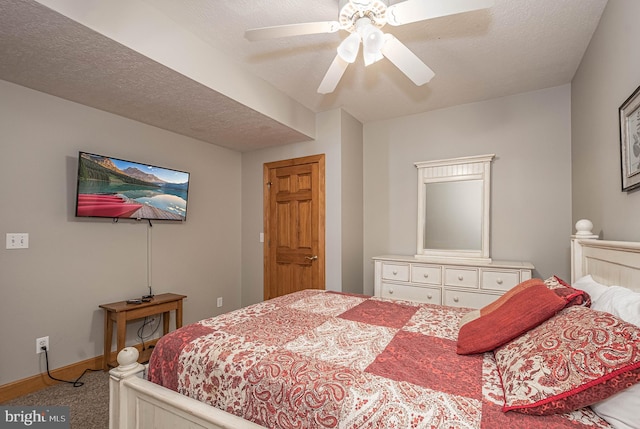 carpeted bedroom with ceiling fan and a textured ceiling