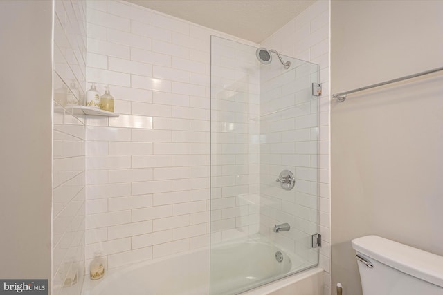 bathroom featuring tiled shower / bath combo and toilet