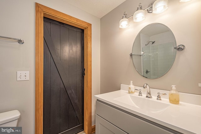 bathroom with walk in shower, vanity, a textured ceiling, and toilet