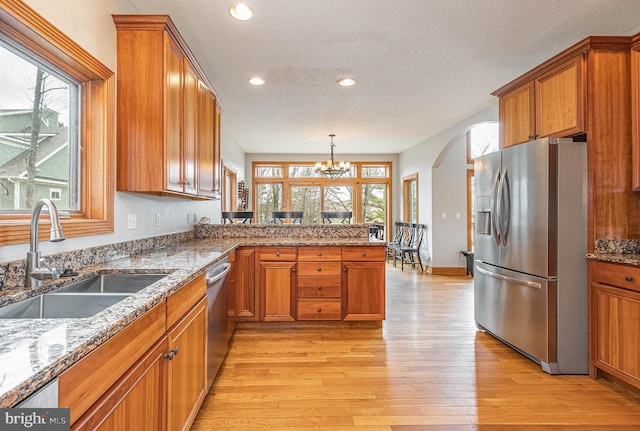 kitchen with light hardwood / wood-style floors, sink, a healthy amount of sunlight, and appliances with stainless steel finishes