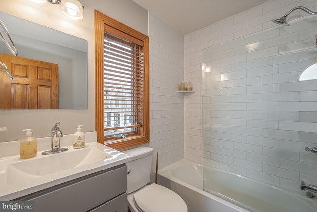 full bathroom with tiled shower / bath, vanity, a healthy amount of sunlight, and toilet