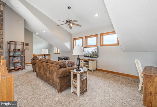 carpeted living room with ceiling fan and vaulted ceiling