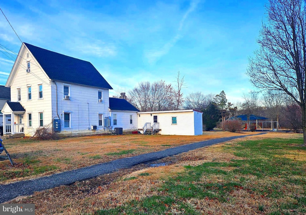 exterior space featuring a front lawn and central air condition unit