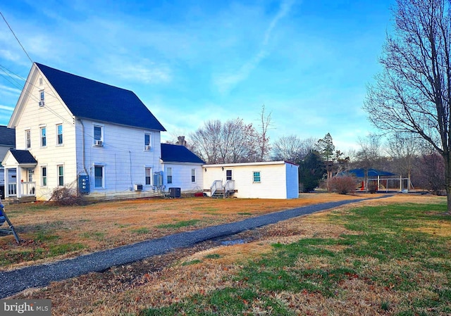 exterior space featuring a front lawn and central air condition unit