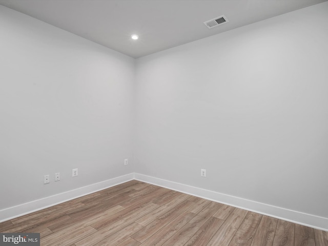 spare room featuring light wood-type flooring, visible vents, baseboards, and recessed lighting