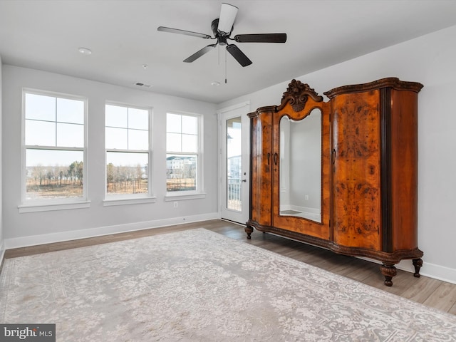 interior space featuring visible vents, ceiling fan, baseboards, and wood finished floors