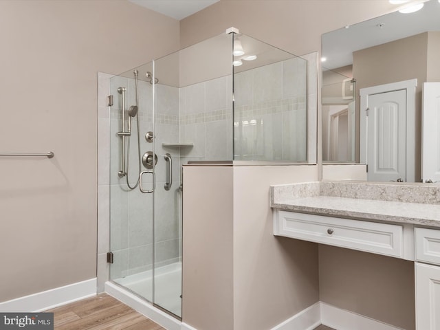 bathroom with vanity, wood-type flooring, and walk in shower