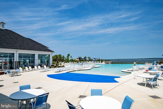 view of swimming pool with a patio and a water view