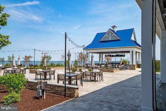 view of property's community featuring a gazebo, a patio area, and a water view