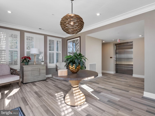 dining space featuring elevator, visible vents, baseboards, and ornamental molding