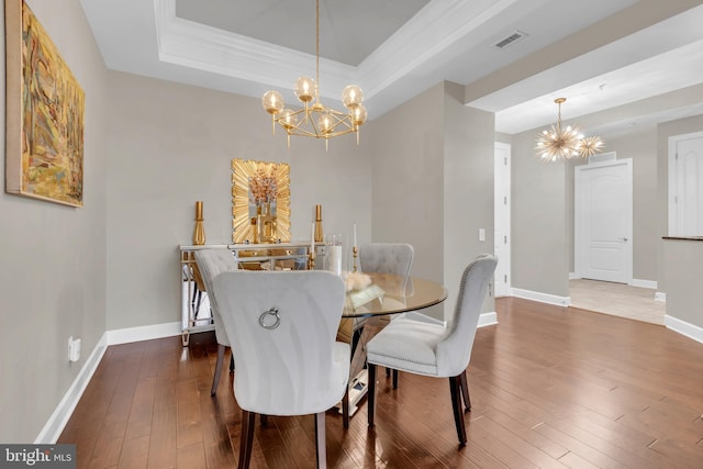 dining space with a tray ceiling, a chandelier, and dark hardwood / wood-style floors