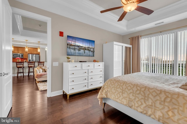 bedroom featuring a tray ceiling, stainless steel fridge, dark hardwood / wood-style flooring, and ceiling fan