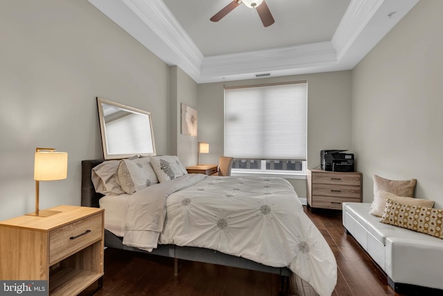 bedroom with a tray ceiling, ceiling fan, dark hardwood / wood-style flooring, and ornamental molding