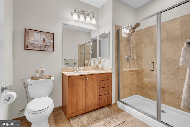 bathroom with tile patterned floors, vanity, toilet, and a shower with shower door