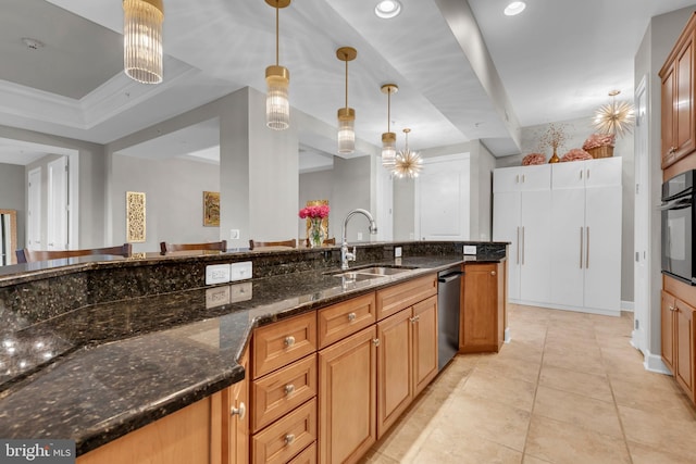 kitchen with dishwasher, sink, oven, dark stone counters, and decorative light fixtures