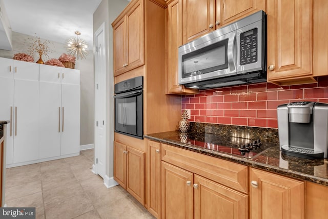 kitchen featuring dark stone countertops, decorative backsplash, light tile patterned floors, and black appliances