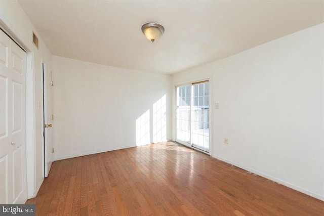 empty room with hardwood / wood-style flooring