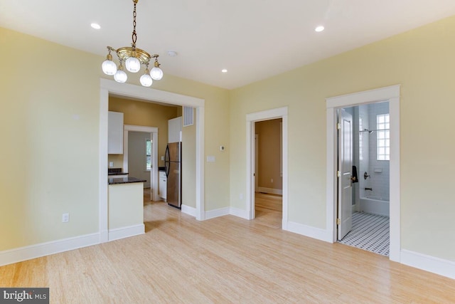 interior space with light hardwood / wood-style floors and a notable chandelier