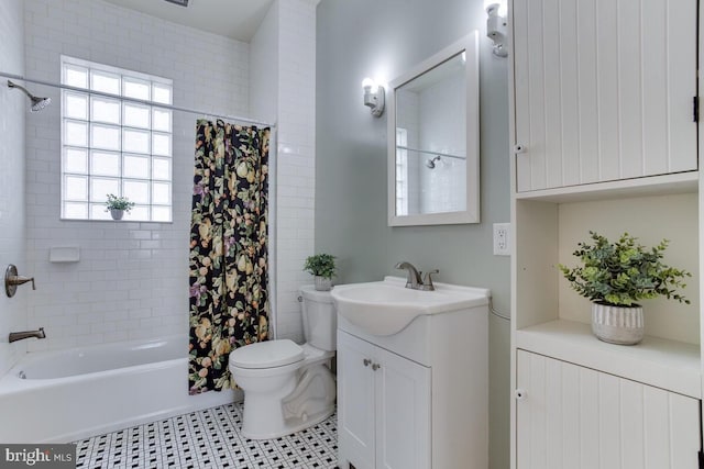 full bathroom featuring tile patterned floors, shower / bath combo with shower curtain, vanity, and toilet