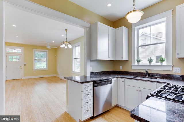 kitchen with stainless steel dishwasher, decorative light fixtures, and white cabinets