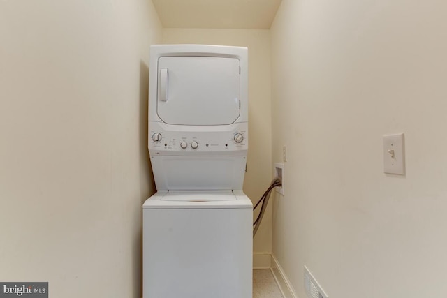 washroom featuring stacked washer and clothes dryer