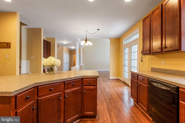 kitchen with decorative columns, black dishwasher, wood-type flooring, hanging light fixtures, and a chandelier