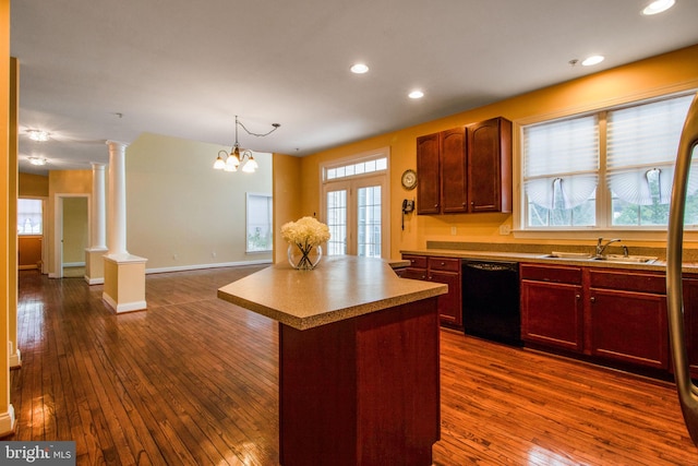 kitchen with dishwasher, a center island, sink, a notable chandelier, and decorative columns