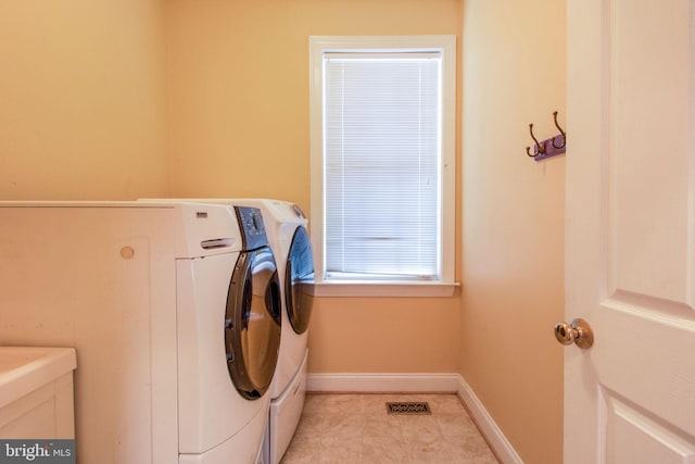 clothes washing area with separate washer and dryer