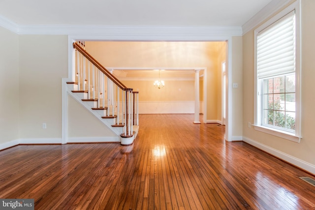 interior space with an inviting chandelier, crown molding, and hardwood / wood-style floors