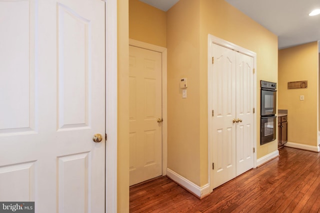 hallway with dark hardwood / wood-style flooring