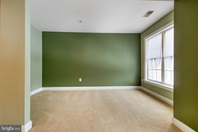 spare room featuring light carpet and a healthy amount of sunlight