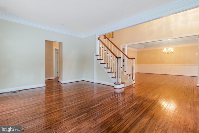 unfurnished living room with hardwood / wood-style floors, ornamental molding, and a chandelier