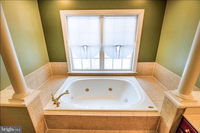 bathroom with tiled tub and vanity