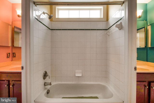 bathroom featuring tiled shower / bath combo and vanity