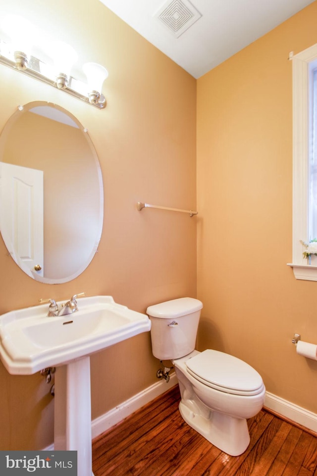 bathroom with toilet and hardwood / wood-style flooring