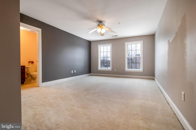 carpeted spare room with ceiling fan