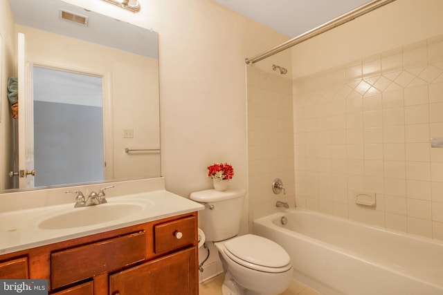 full bathroom featuring toilet, tiled shower / bath, and vanity