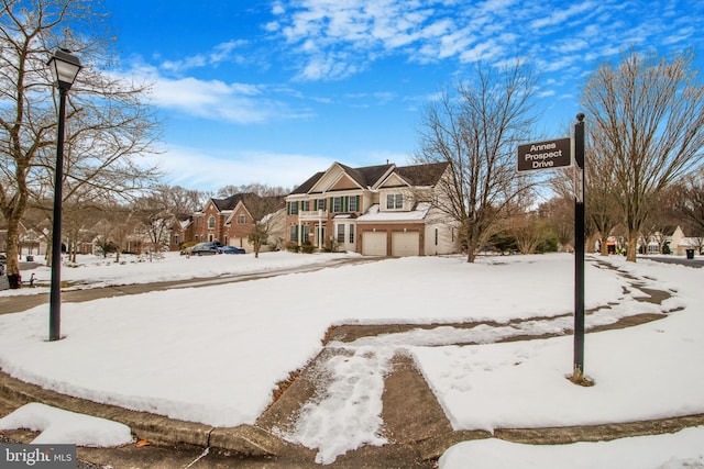 snowy yard featuring a garage