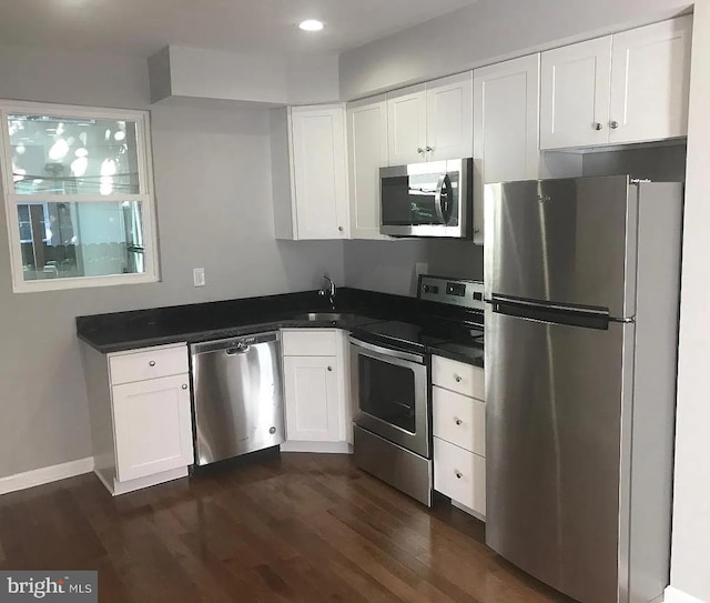 kitchen featuring dark hardwood / wood-style flooring, stainless steel appliances, white cabinetry, and sink