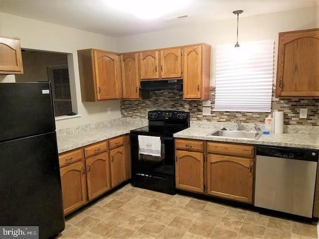 kitchen featuring backsplash, pendant lighting, black appliances, and sink