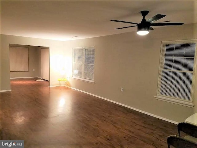 empty room with ceiling fan and dark hardwood / wood-style flooring