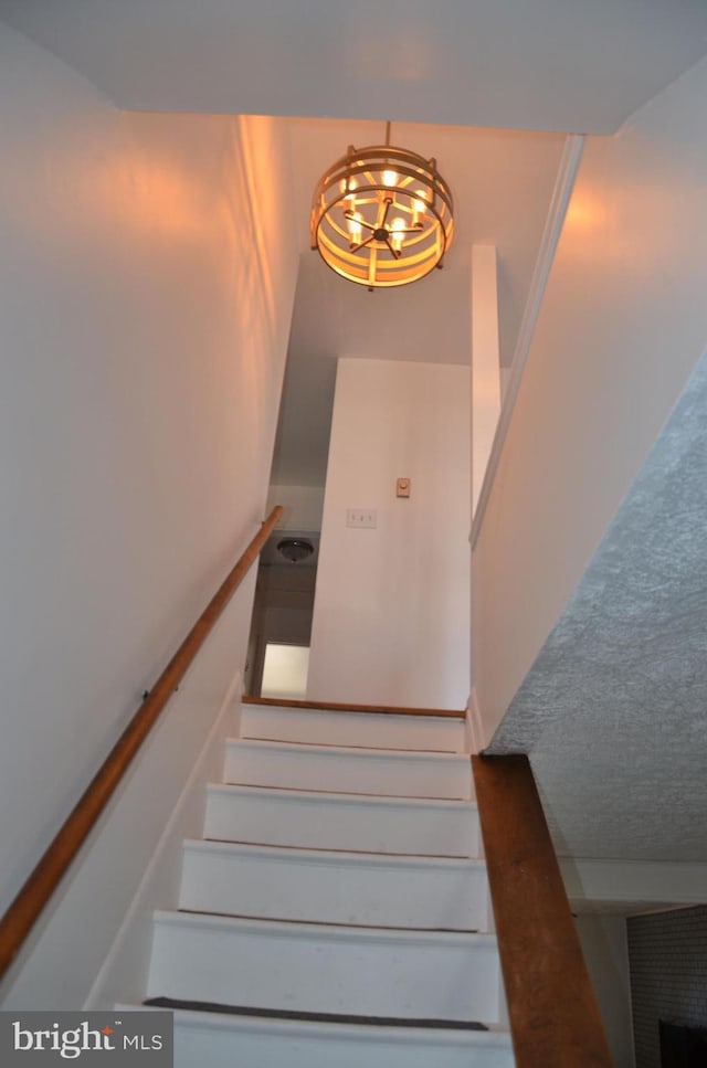 stairs with a chandelier