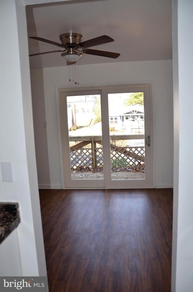 spare room featuring ceiling fan and dark wood-type flooring