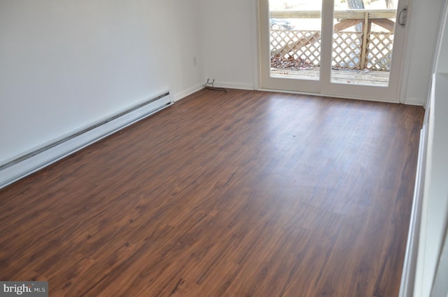 unfurnished room featuring dark hardwood / wood-style floors and a baseboard heating unit