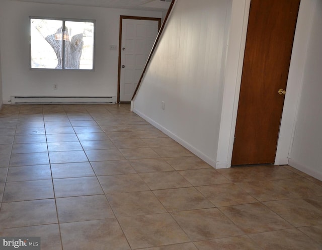 spare room featuring light tile patterned flooring and a baseboard heating unit