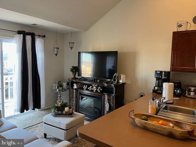 living room featuring lofted ceiling and sink