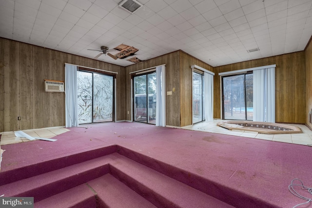 interior space featuring carpet, ceiling fan, an AC wall unit, and wooden walls