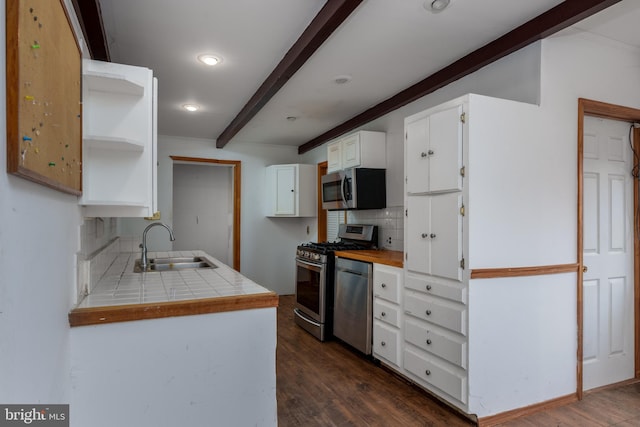 kitchen with tile countertops, white cabinets, sink, decorative backsplash, and stainless steel appliances