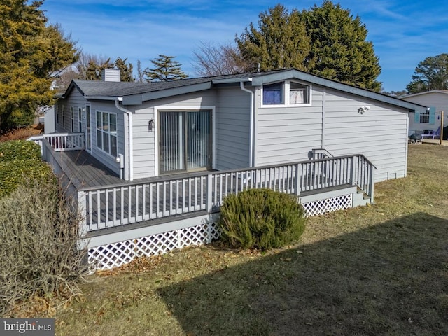 rear view of house featuring a yard and a deck